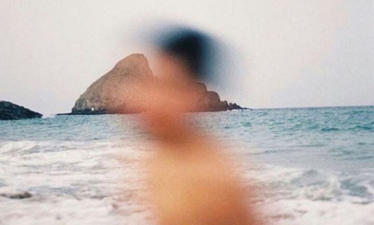 A swimmer in the shallows, an island behind